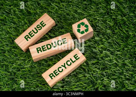 Riutilizzo Riduci il testo e il simbolo del riciclo sul concetto di sostenibilità dei blocchi di legno Foto Stock