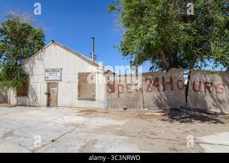 Un garage abbandonato aperto 24 ore su 24 si trova vicino al distributore di benzina Mohawk e al mini-market sulla vecchia Route 66 a Oro grande, California. Foto Stock