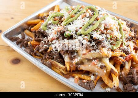 Vista su un vassoio di patatine di carne asada. Foto Stock