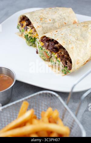 Una vista di un burrito carne asada, tagliato a metà. Foto Stock