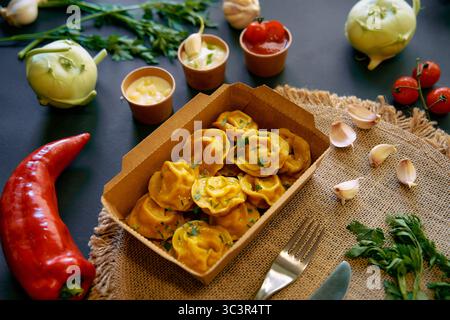 Una deliziosa serie di bocconcini fatti in casa serviti in un ambiente rustico circondato da ingredienti freschi e salse saporite per una gustosa esperienza culinaria Foto Stock