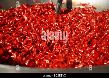 Taglio di peperoncini secchi tritati rossi, peperoncino fresco saltato in padella per preparare la pasta al curry. Foto Stock