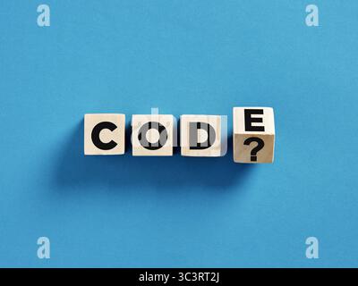 Hacking di codice, cybercrimine, cyberattacco e concetto di dark web. Cubi di legno con il codice della parola e il punto interrogativo. Foto Stock
