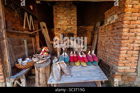 Scarpe e pantofole in feltro di lana in stile locale in vendita presso uno stallo a Viscri, un villaggio sassone della regione di Brasov in Transilvania, Romania Foto Stock
