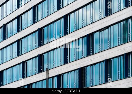 Facciata in vetro color crema e blu con finestre a griglia Foto Stock