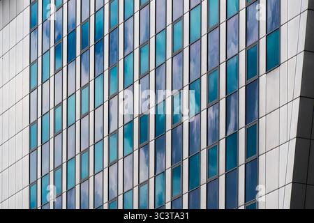 Facciata in vetro color crema e blu con finestre a griglia Foto Stock