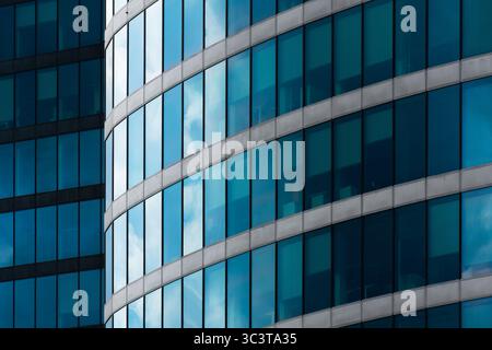 Torre per ufficio curva con parete continua in vetro blu Foto Stock