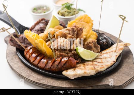 Fajitas di pollo e manzo sfrigolanti con peperoni grigliati e cipolle su padella in ghisa. Cucina messicana Tex-Mex fresca con lime e tortillas. Foto Stock