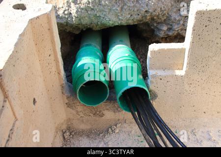 Le linee elettriche vengono condotte attraverso un tubo in un edificio Foto Stock