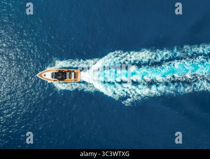 Vista aerea del motoscafo in acque turchesi cristalline al tramonto Foto Stock