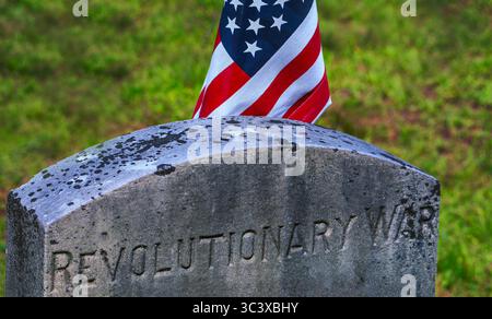 Il grave marker onora un soldato che ha combattuto nella Guerra d'indipendenza nota anche come Guerra d'indipendenza. E' decorata con una bandiera. Foto Stock