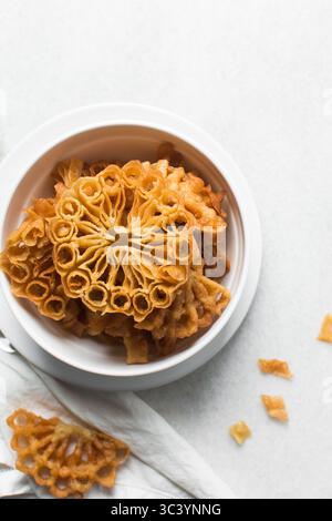 Vista dall'alto dello snack sassafa nigeriano settentrionale, vista dall'alto dei biscotti alle rosette in una ciotola bianca Foto Stock