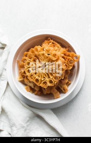 Vista dall'alto dello snack sassafa nigeriano settentrionale, vista dall'alto dei biscotti alle rosette in una ciotola bianca Foto Stock