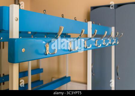 Primo piano di un gancio argentato su un portabiti in uno spogliatoio sportivo. Foto Stock