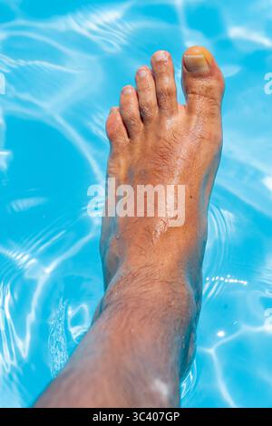 Bellissimi piedi con 30 centimetri di bianco uomo caucasico all'interno di acqua blu e piscina Foto Stock