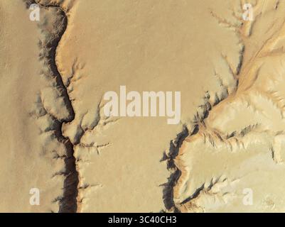 Veduta aerea degli aspri canyon della terra arroccata, incisi dal tempo e dagli elementi, che rivelano una dura bellezza sotto il sole duro, la valle di Tsondab, Khomas, Namibia. Foto Stock