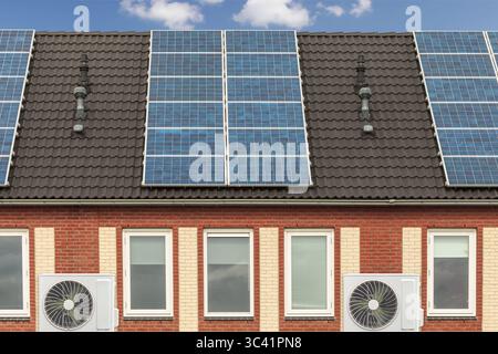 Fila di nuove case olandesi con pannelli solari e pompe di calore a sorgente d'aria Foto Stock