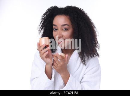 Bella donna brasiliana con barattolo di crema al collagene su sfondo bianco Foto Stock