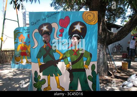 Due persone stanno posando per una foto con i loro volti nelle fessure di un tabellone dipinto. La tavola ha un design a fumetti con le parole "Porto de Galinhas" Foto Stock