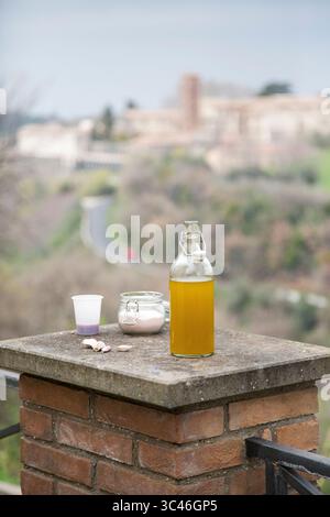 C'è una bottiglia di olio d'oliva che poggia su una robusta sporgenza in mattoni Foto Stock