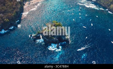 Vista droni di Nusa Penida con Crystal Bay, isola rocciosa e oceano con barche. Foto Stock