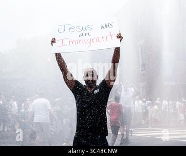 30 giugno 2018 - Washington, District of Columbia, Stati Uniti - JONATHAN REED di Silver Spring, MD, tiene un cartello mentre si prende il raffreddamento in una stazione di raffreddamento prima del " Families Belong Together Rally". REED of Silver Spring, MD, tiene un cartello mentre si rinfrescano in una stazione di raffreddamento prima del "Families Belong Together Rally". Di Silver Spring, MD tiene un cartello mentre si prende il raffreddamento in una stazione di raffreddamento prima che il "Families Belong Together Rally". (Immagine di credito: © Michael A. McCoy via ZUMA Wire) Foto Stock