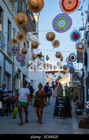 Strada decorata con cappelli appesi ad Alberobello, Puglia, Italia Foto Stock