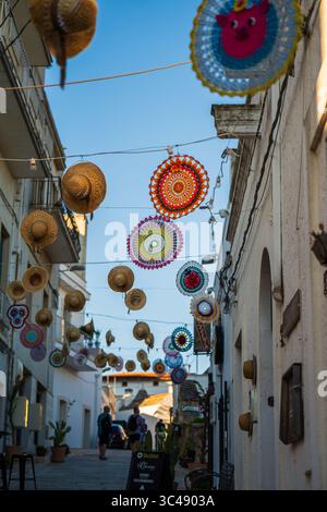 Strada decorata con cappelli appesi ad Alberobello, Puglia, Italia Foto Stock