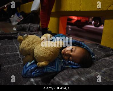 1° luglio 2018 - Matamoros, Messico - 2 luglio 2018 - Matamoros, Messico - Ingrid Perdomo, 18 anni, e suo figlio di 1 anno Jose Luis con altri richiedenti asilo dormono sul ponte Gateway International in attesa di attraversare gli Stati Uniti dal lato del Messico. È venuta con il suo compagno Luis Miguel, 32 anni dall'Honduras, dove hanno fatto il difficile viaggio di 3 mesi. Ha detto di essere fuggito nella paura e piange molto con ansia per il suo passato. La sua ex moglie ha iniziato a frequentare un membro della gang e la gang ha incendiato la sua casa uccidendo i suoi due figli all'interno. Fuggì sulle montagne in cerca di sicurezza, dove incontrò Ingrid e ebbero un altro figlio. Wow Foto Stock