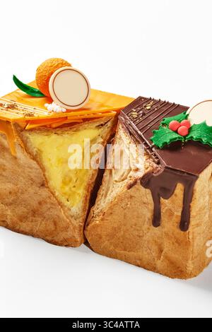 Pane a forma cubica tagliato a metà con ripieno di panna, uno con guarnizione di cioccolato e decorazione natalizia e uno con ripieno di arancia Foto Stock