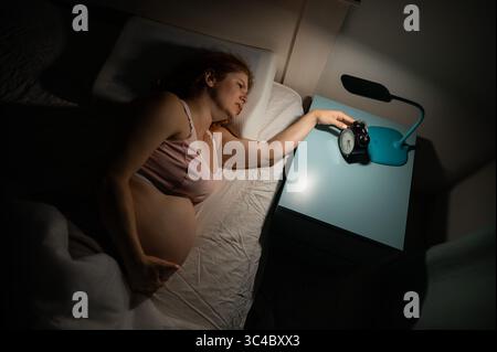 La donna incinta soffre di dolore di notte. Foto Stock