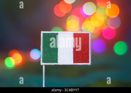 Bandiera italiana con vivace sfondo bokeh festivo. Rappresenta l'orgoglio nazionale, le celebrazioni delle vacanze, l'eco-turismo, l'unità e la luminosità culturale. Foto Stock