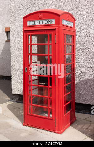 Una cabina telefonica rossa all'angolo di una strada utilizzata per effettuare chiamate dal pubblico Foto Stock