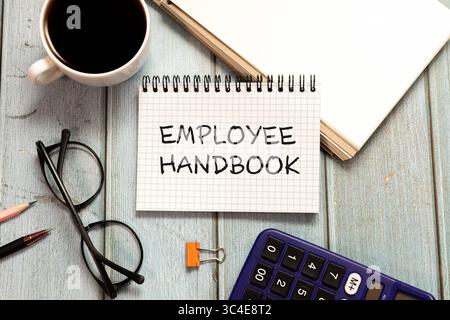 Testo del manuale per i dipendenti scritto sul notebook. Foto Stock