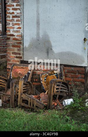 Due sedie di legno rotte in una vecchia casa abbandonata, che mostrano degrado e negligenza. Ideale per i temi di esplorazione urbana o per la narrazione visiva del tempo A. Foto Stock