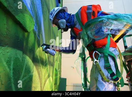 31 agosto 2018 - St. Petersburg, Florida, Stati Uniti - SCOTT KEELER | Times. L'artista murale Derek Donnelly, Pinellas Park, utilizza la vernice spray per completare un murale al Sirata Beach Resort, St. Pete Beach, venerdì 31 agosto 2018. Il lavoro murale fa parte di una ristrutturazione da 15 milioni di dollari per l'azienda. Donnelly ha detto che il murale, che presenta una lucertola di geco e piante tropicali, gli ha impiegato una settimana per completarlo. Il murale si trova vicino alla spiaggia in uno spazio per eventi attualmente in fase di costruzione. (Immagine di credito: © Scott Keeler/Tampa Bay Times tramite ZUMA Wire) Foto Stock