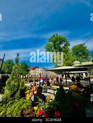 Sorseggiando un drink e socializzando al ristorante Kappeli di Eteläesplanadi a Helsinki, Finlandia. Foto Stock