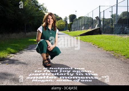 EMBARGO AL 0001 MERCOLEDÌ LUGLIO 30 USO EDITORIALE SOLO Izzy Judd al Wimbledon Park di Londra, come parte della campagna positive Steps di BACP, dove storie personali sono dipinte lungo un percorso per evidenziare come la terapia ha aiutato le nuove mamme. Data di pubblicazione: Mercoledì 30 luglio 2025. Foto Stock