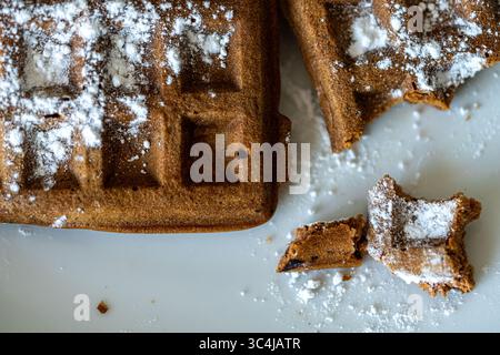 Cialde di pasta al cioccolato belga cosparse di zucchero a velo su sfondo bianco. Vista dall'alto. Primo piano. Foto di alta qualità Foto Stock