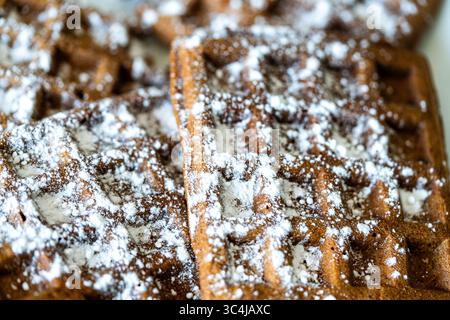 Cialde di pasta al cioccolato belga cosparse di zucchero a velo su sfondo bianco. Vista dall'alto. Primo piano. Foto di alta qualità Foto Stock