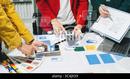 Vista ravvicinata del team di sviluppatori dell'interfaccia utente che ha avviato un brainstorming sul proprio progetto con laptop, smartphone e tablet digitale. Agenzia di sviluppo digitale creativo. Foto Stock