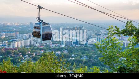 Almaty, Kazakistan - 12 giugno 2025 - funivia Kok-Tobe con paesaggio urbano di Almaty sullo sfondo Foto Stock