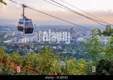 Almaty, Kazakistan - 12 giugno 2025 - funivia Kok-Tobe con paesaggio urbano di Almaty sullo sfondo Foto Stock