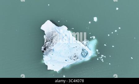 La vista aerea di un iceberg incontaminato galleggia maestosamente nelle acque turchesi, creando un incredibile contrasto di blu ghiacciato e verdi sereni, il Cile. Foto Stock