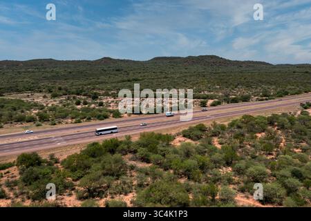 autostrada con vista aerea, autobus, camion, macchinette, paesaggio africano e colline, nuovi sviluppi nei trasporti, giorno Foto Stock