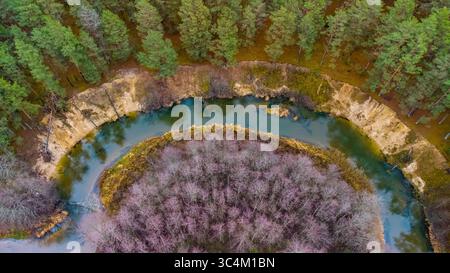 Vista dall'alto della curva tortuosa del fiume Ūla-Pelesa, circondata da foreste e ripide rive sabbiose. Una formazione naturale unica nel bosco Foto Stock