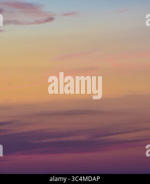 Le delicate nuvole illuminate dal tramonto formano un tranquillo e mozzafiato panorama sopra il mondo. Foto Stock