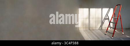 Scala a cavalletto rossa in camera vuota, senza lavori di ristrutturazione. sfondo grigio. Concetto di riparazione Foto Stock