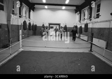 Boxing club de Ring, Eksterstraat, IJmuiden, pugilato, IJmuiden, paesi Bassi, 14-03-1989 Whizgle News, Dutch Desk, Paesi Bassi, 1950-2000 Un gruppo di individui pratica le proprie tecniche di pugilato in un'ampia struttura di allenamento, circondata da borse di pugno appese e un anello di pugilato, sottolineando l'attenzione e la dedizione degli atleti. Foto Stock