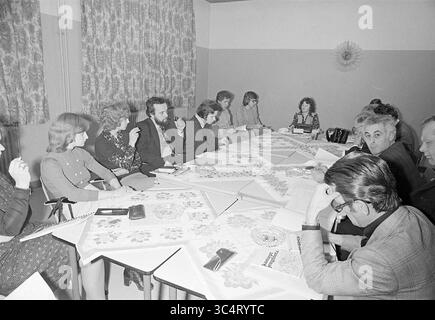Zandvoort Youth council Meeting, Meetings, 26-03-1975 Whizgle News, Dutch Desk, Paesi Bassi, 1950-2000 Un gruppo diversificato di persone è riunito intorno a un grande tavolo coperto di documenti e quaderni, impegnato in una discussione. L'ambiente presenta tende a motivi geometrici e un arredamento semplice, suggerendo una riunione incentrata sulla collaborazione e il processo decisionale. Foto Stock
